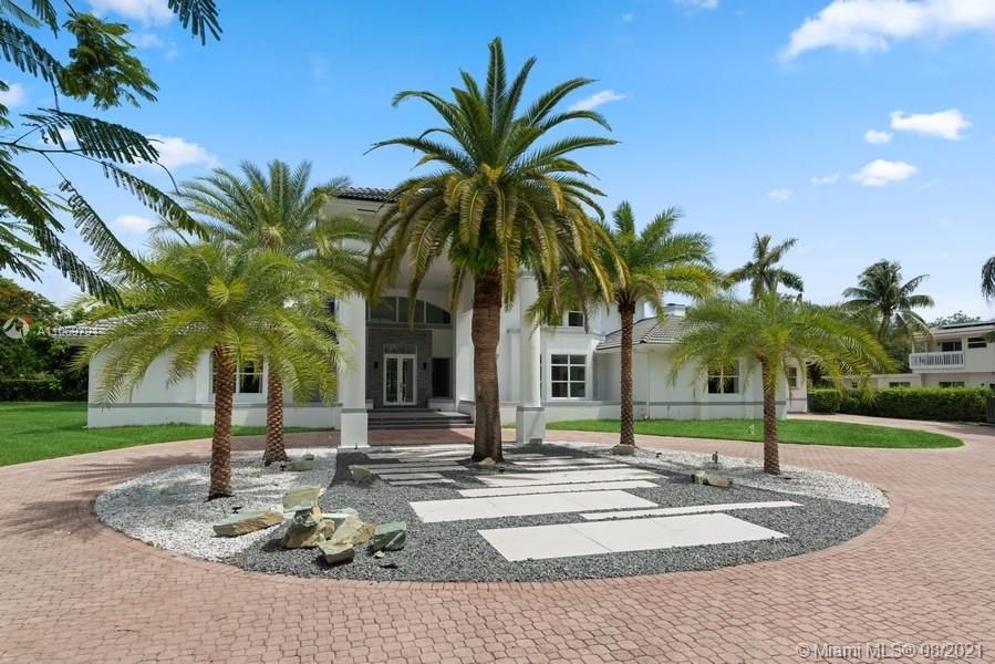 Impressive palm trees and clean, modern landscaping adorn the entrance.