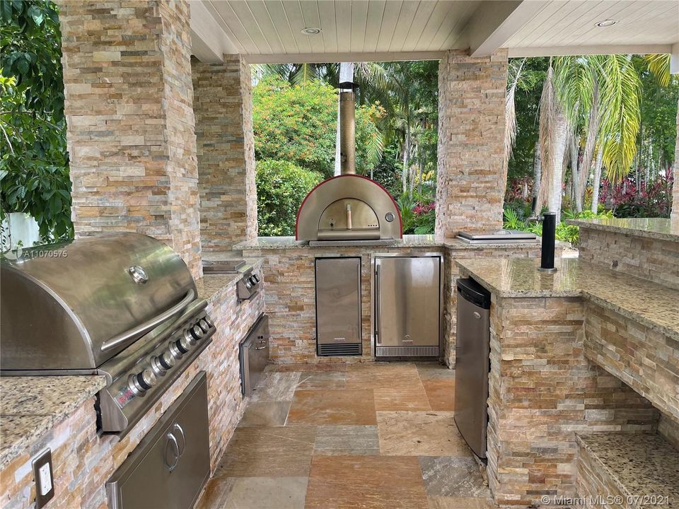 summer kitchen has a built in bbq and a pizza oven