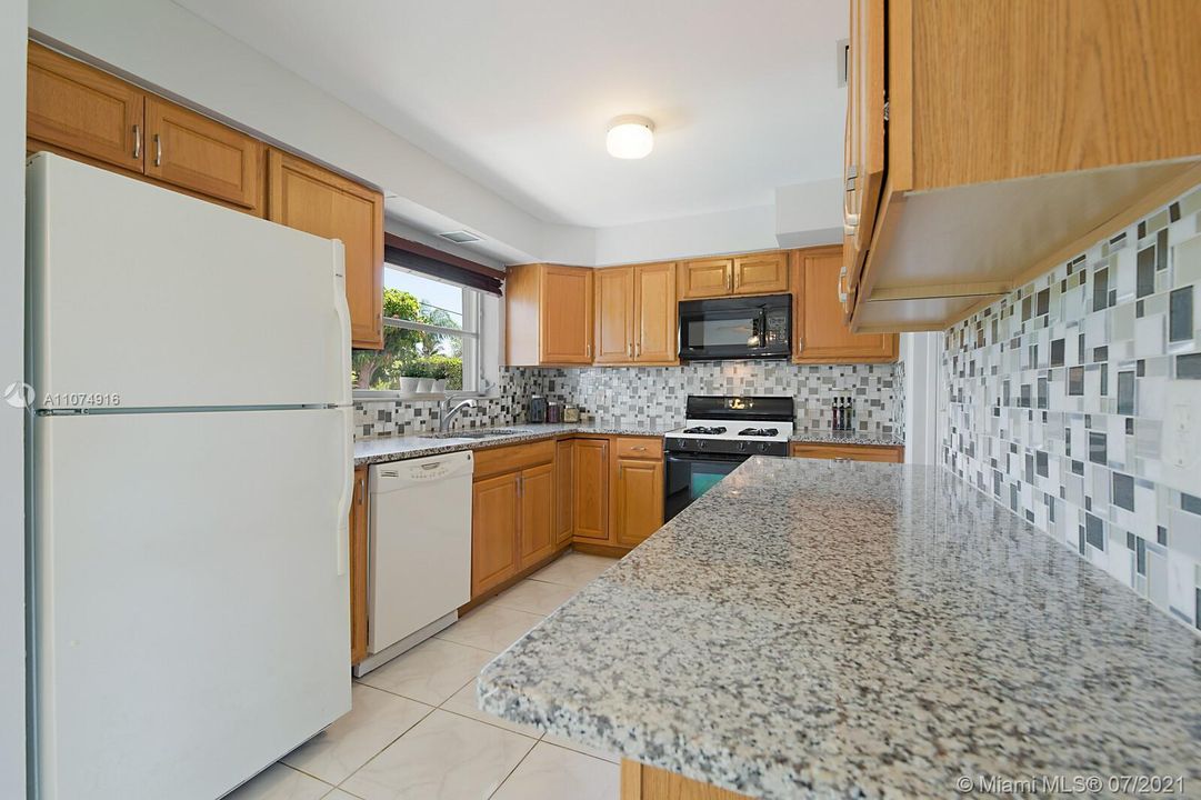 Spacious kitchen with updated wood cabinets & granite counters