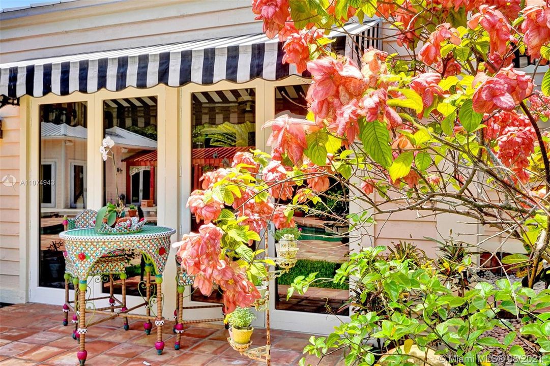 Lovely flowers surround the back patio. Awning to cover seating area.