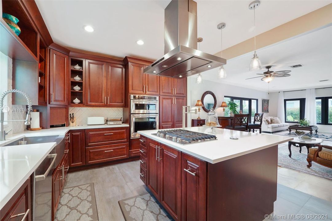 Chef's Kitchen with gas cooking, large island and stainless convection hood.