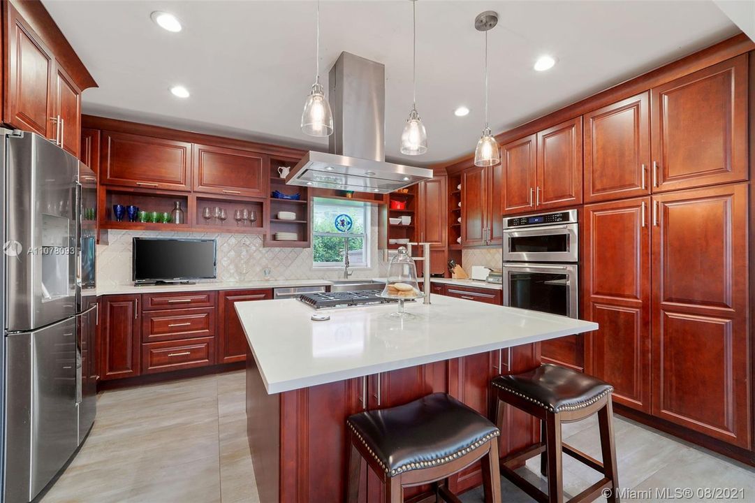 Eat-in kitchen with bar-top seating with large center prepping and serving island.