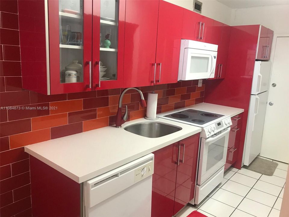 Red glossy cabinets and back splash in the kitchen