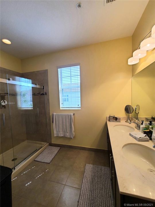 Master bathroom with upgraded rolling glass shower doors, tile shower