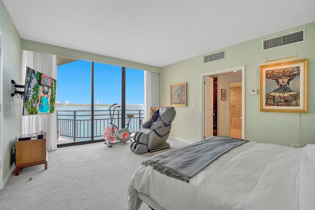 Master bedroom with expansive water view and balcony access