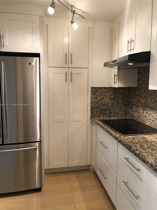 Kitchen features stainless steel appliances and cooktop.