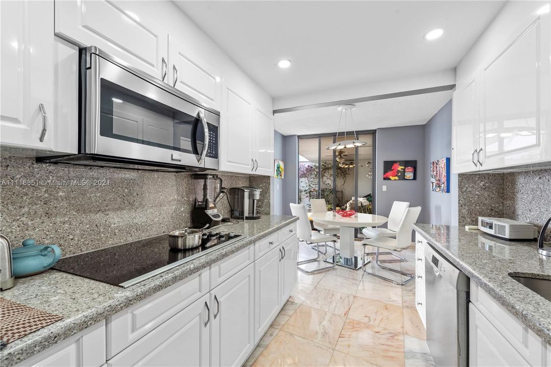 Beautiful contemporary white kitchen with marble countertops/backsplash!