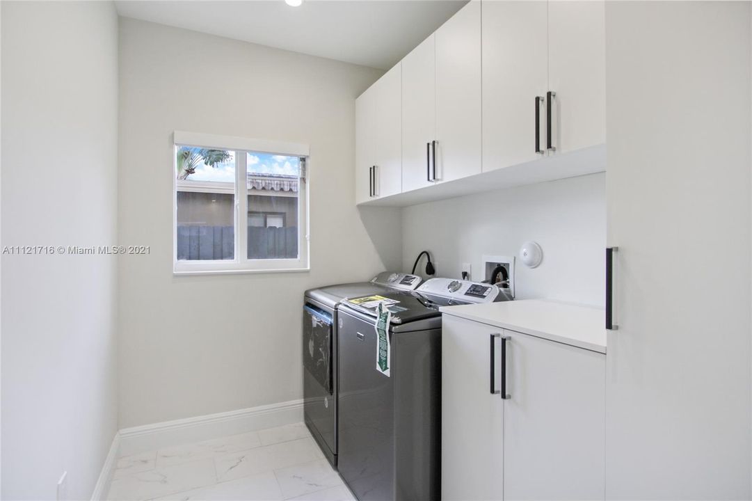 LAUNDRY ROOM WITH UPGRADED APPIANCES AND PLENTY OF CABINETRY.