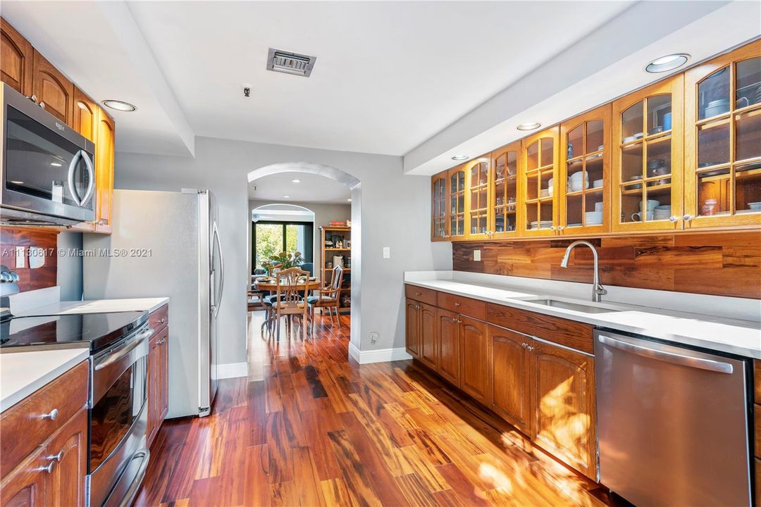 Sun-filled kitchen with stainless steel appliances, and beautiful wooden backsplash!