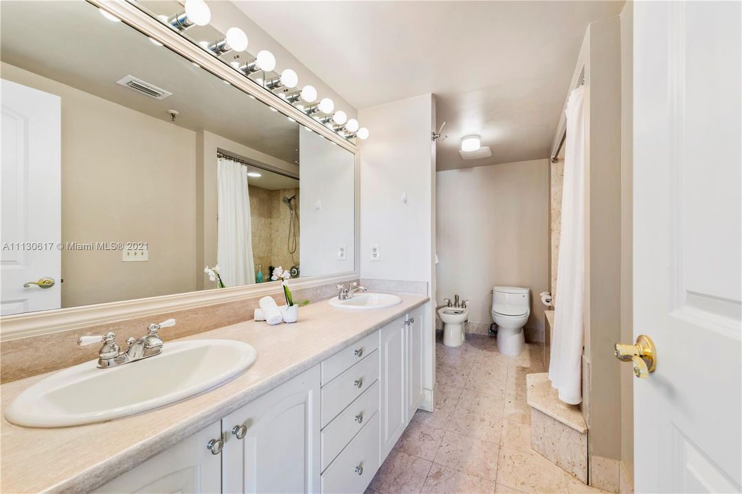 Spa like master bathroom with dual sinks & marble countertops.