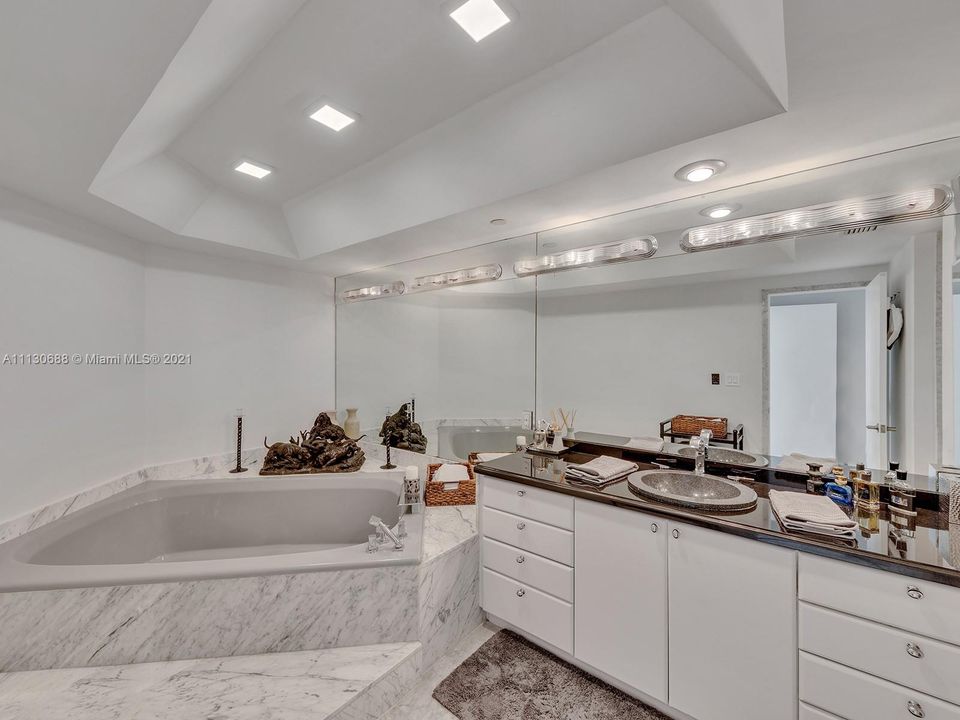 LARGE PRIMARY MARBLE BATH FEATURES DOUBLE SINKS, SPA TUB, SHOWER, AND BIDET.