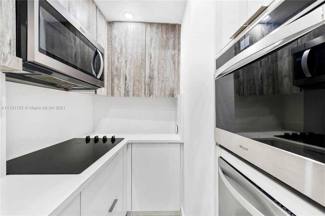 Gorgeous white kitchen with stainless steel appliances.