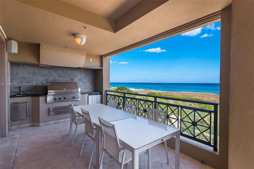 Covered oceanfront balcony featuring built in grill, refrigerator and sink.