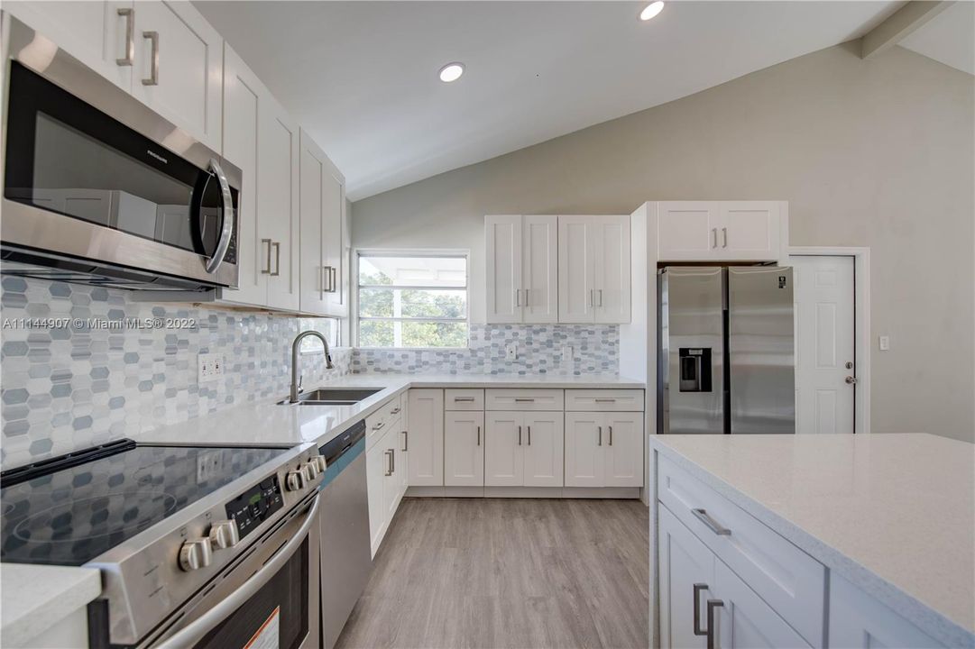 Quartz waterfall counters and stainless steel appliances