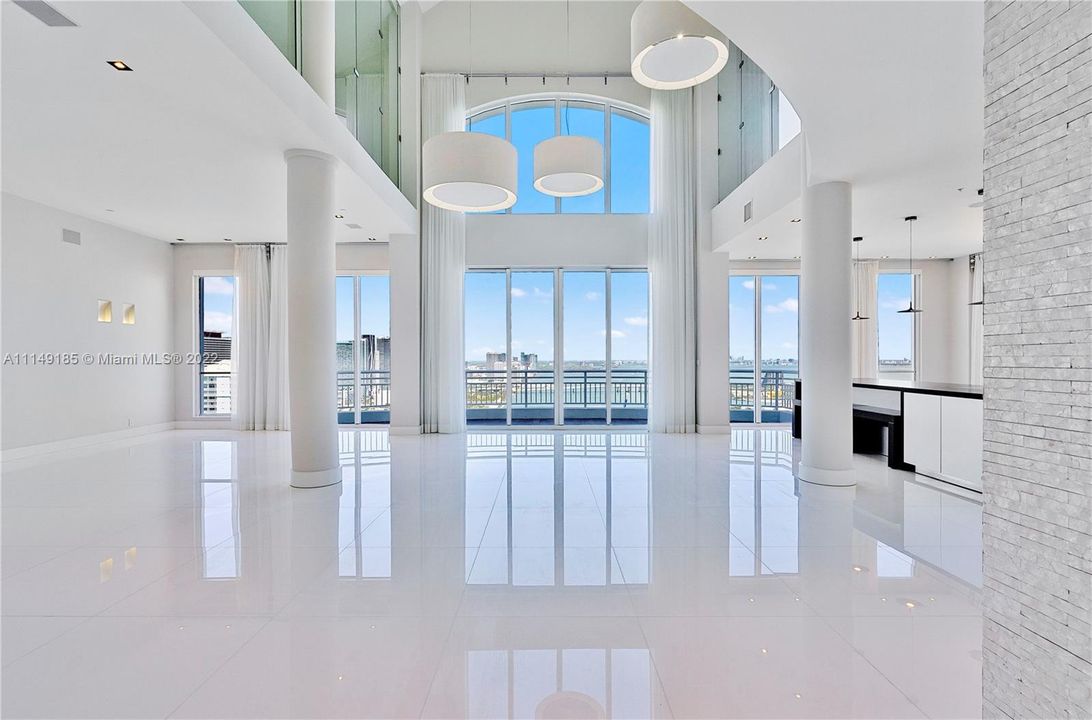 Enter into your 2 story top floor Penthouse with 30+ ft ceilings and a giant living/dining/kitchen area with stunning bay/ocean/city views.