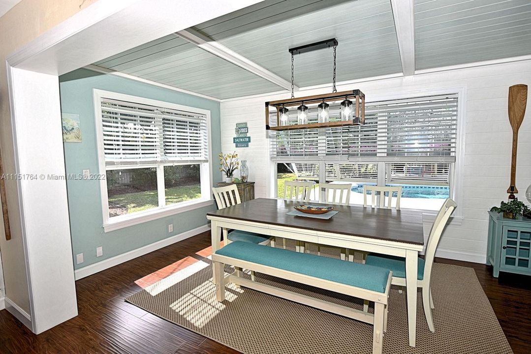 Bight cheery dining room over looking the gorgeous backyard and pool .