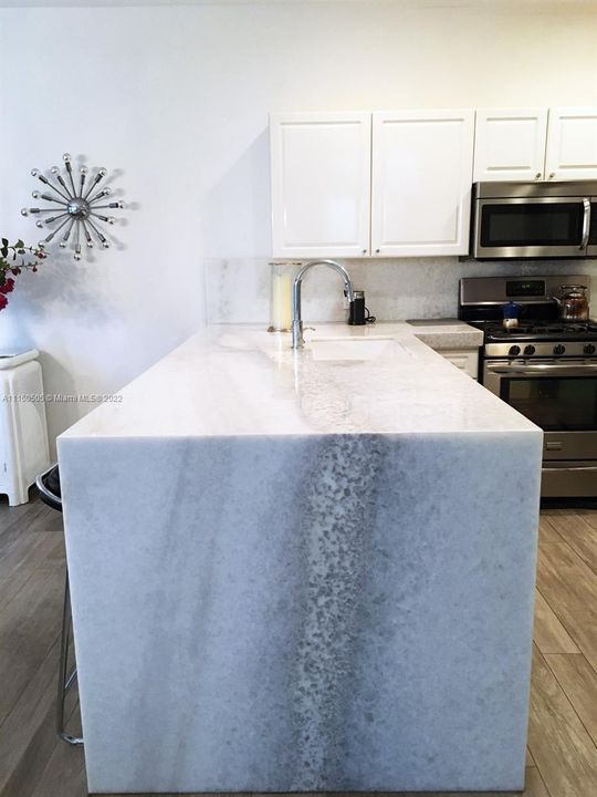 Kitchen with waterfall counter top.