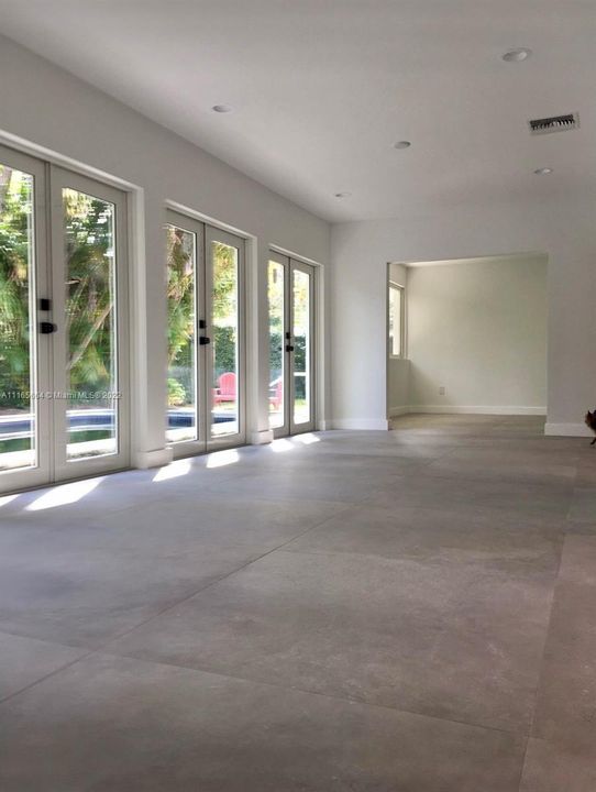 French Doors leading to Pool Area + Den + 40' Seamless Flooring
