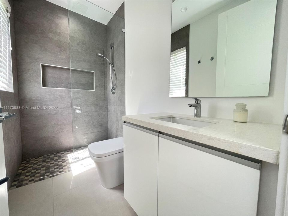 Second full bathroom with glass enclosed shower.