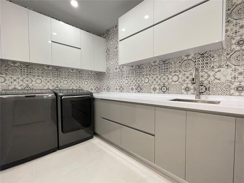 Beautifully renovate laundry room with Italian Cabinets and quartz countertops.