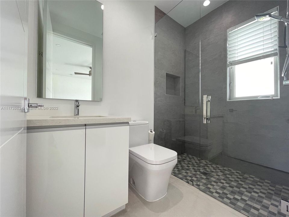 Full bathroom with glass enclosed shower.