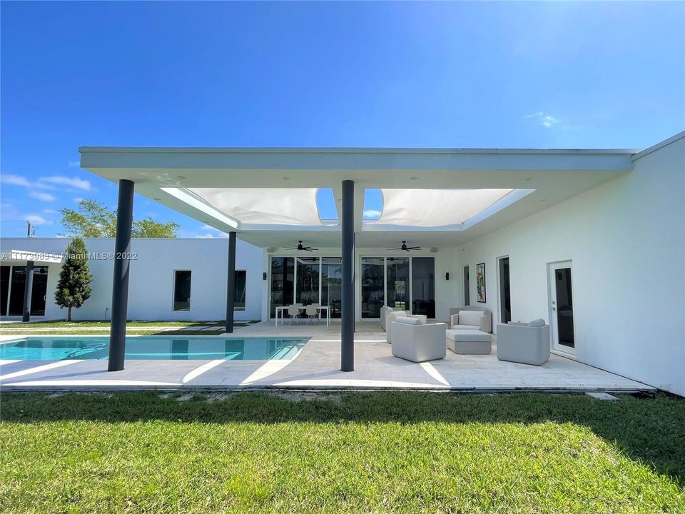 Exterior entertainment area with large pool and covered terrace.