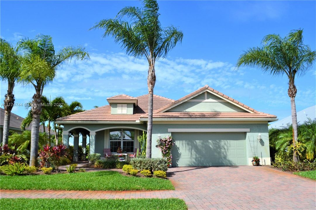 Welcome home to this sophisticated yet casual lakefront home. That's surrounded by dozen of Queen and assorted palm trees, a Poinciana and flowering shrubs!