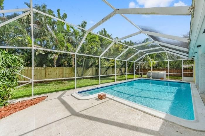 View of the Pool looking south. Notice the easy steps into the shallow end of the pool. Also notice the privacy fence and beautiful palms that just bring the Tropical Paraidise of South Florida to your new home!