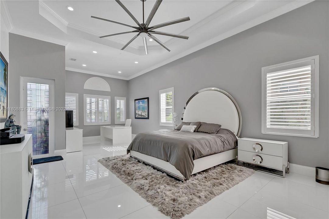 Master Bedroom with Large Sitting area, Bahama Shutters, and Entrance to Pool, Patio & Lake!