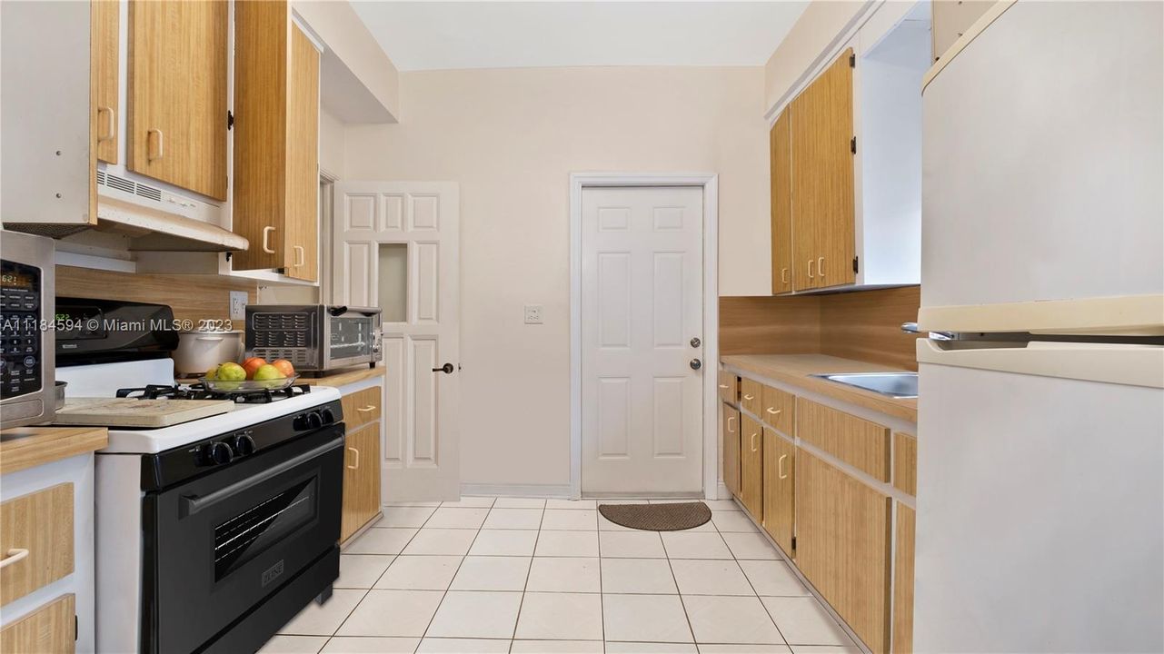 Galley style kitchen with access to the backyard and outdoor covered laundry room
