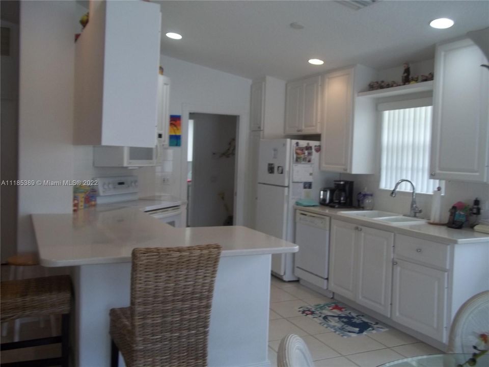 Open kitchen, tile floor, white cabinets