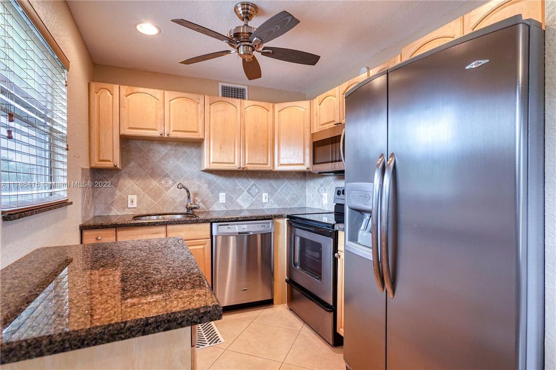 Updated kitchen featuring wood cabinets, granite countertops, and stainless steal appliances.