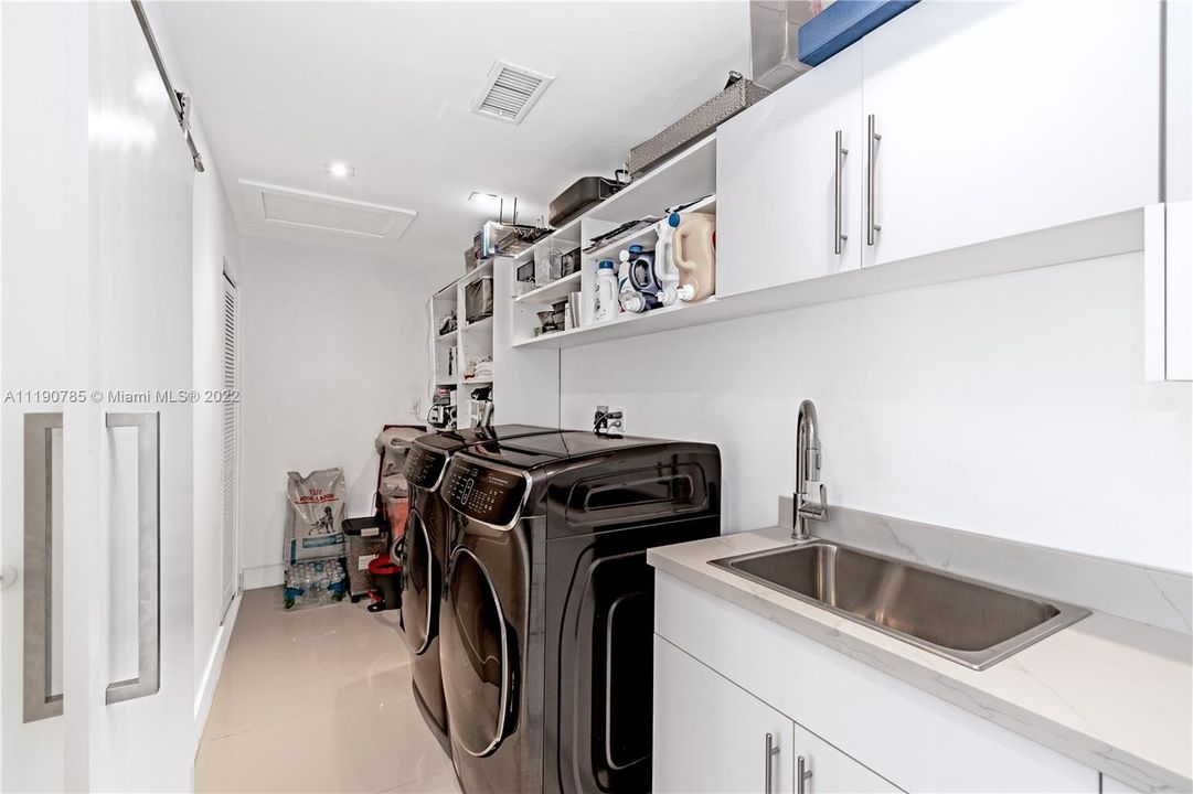 Large Laundry room with front smart technology Samsung front loaders and plenty of storage space.