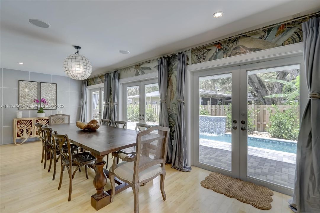 Tropical wall coverings, window drapes and wall detailing in the dining room overlooking the patio