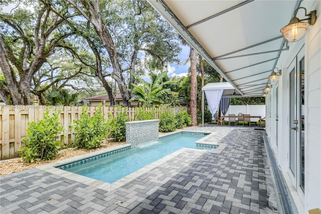 Pool w/ water feature & Swim Jets. Canvas Awnings on both sides, paved patio