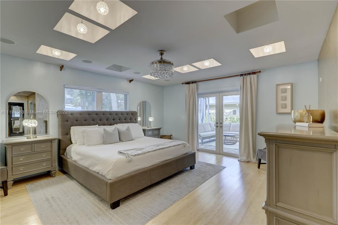 Primary Bedroom w/ ceiling troughs w/ French Doors to Patio