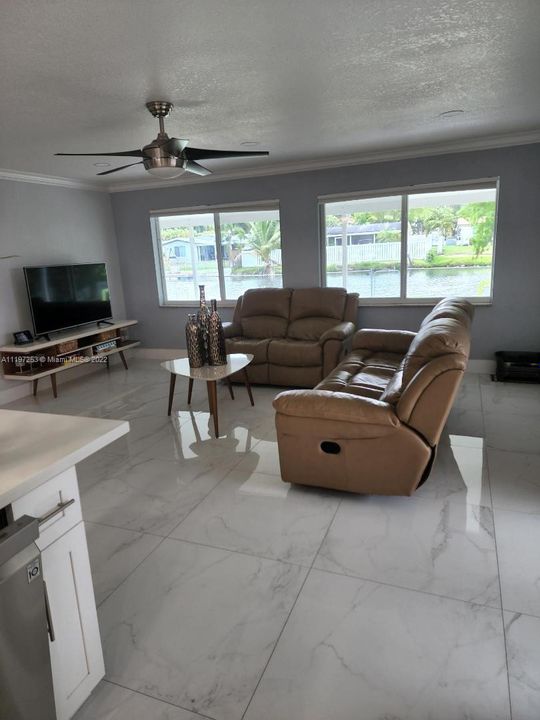 Family room with impact windows overlooking canal