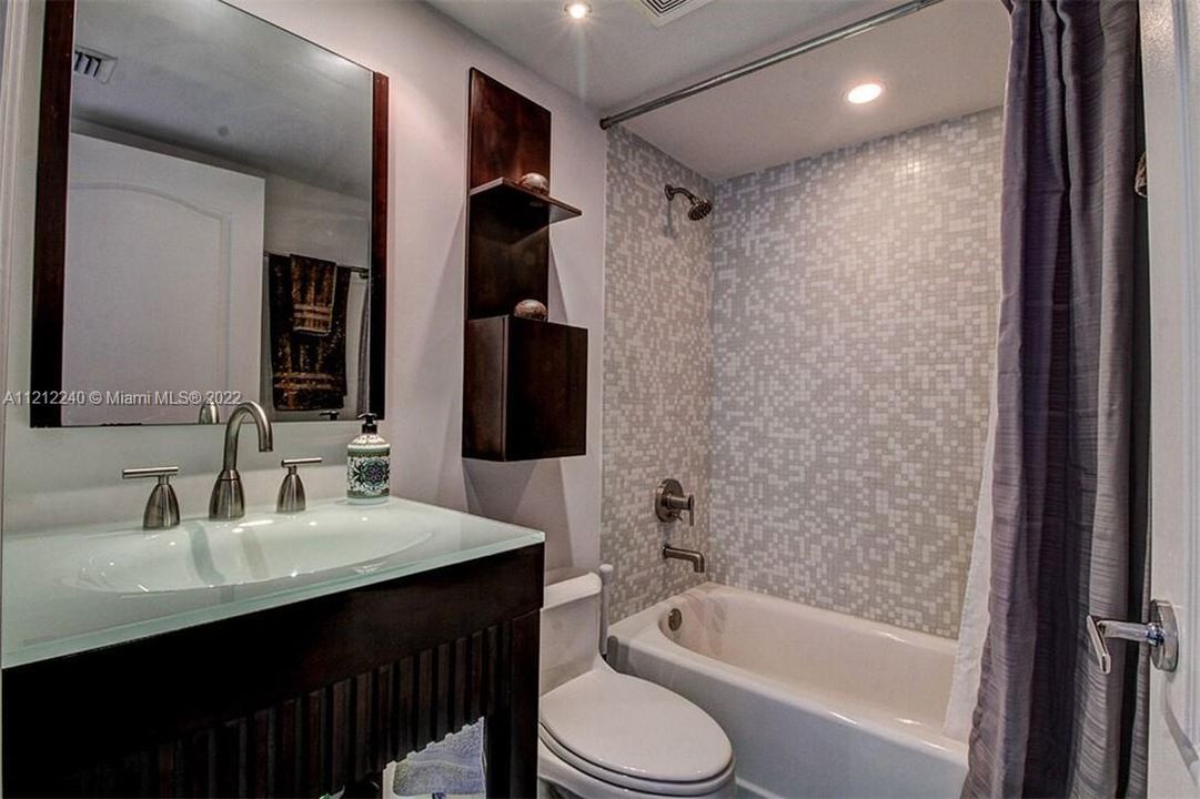 Second guest bathroom with upgraded vanity, mosaic tile throughout, and combo shower/tub.