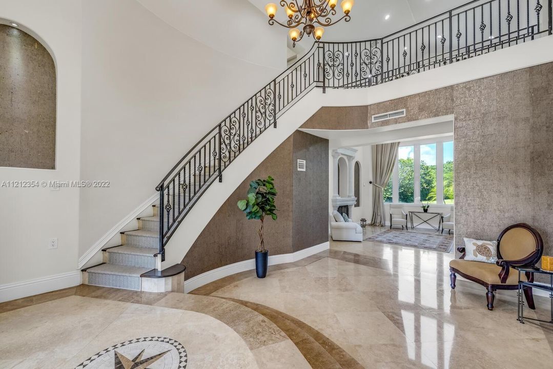 Foyer and stairs with view to formal living room.