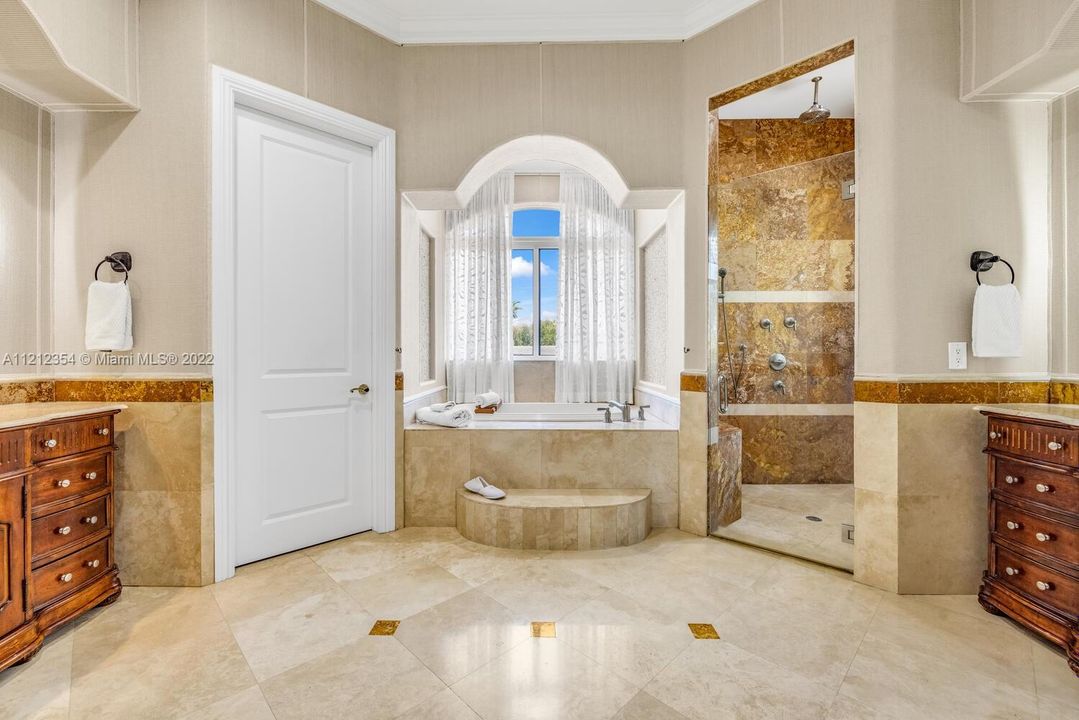Master bathroom with jacuzzi roman tub, dual vanities, shower on right, toilet and bidet on left.