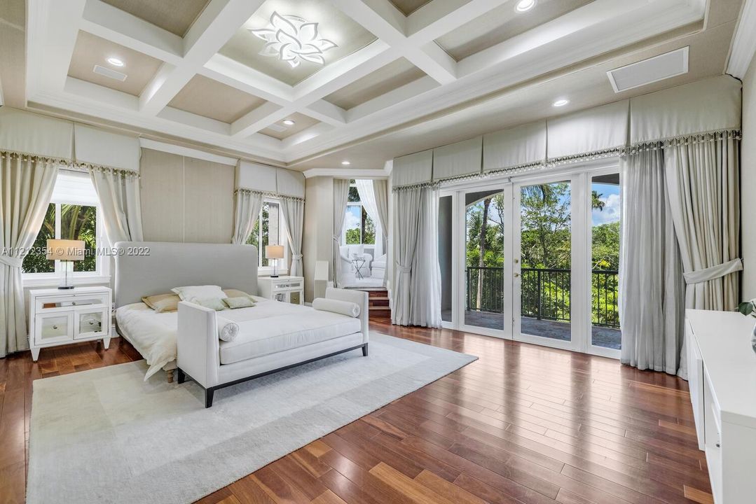 Master bedroom with coffered ceiling and floor to ceiling doors for expansive lake views, beyond is the parlor/observatory.