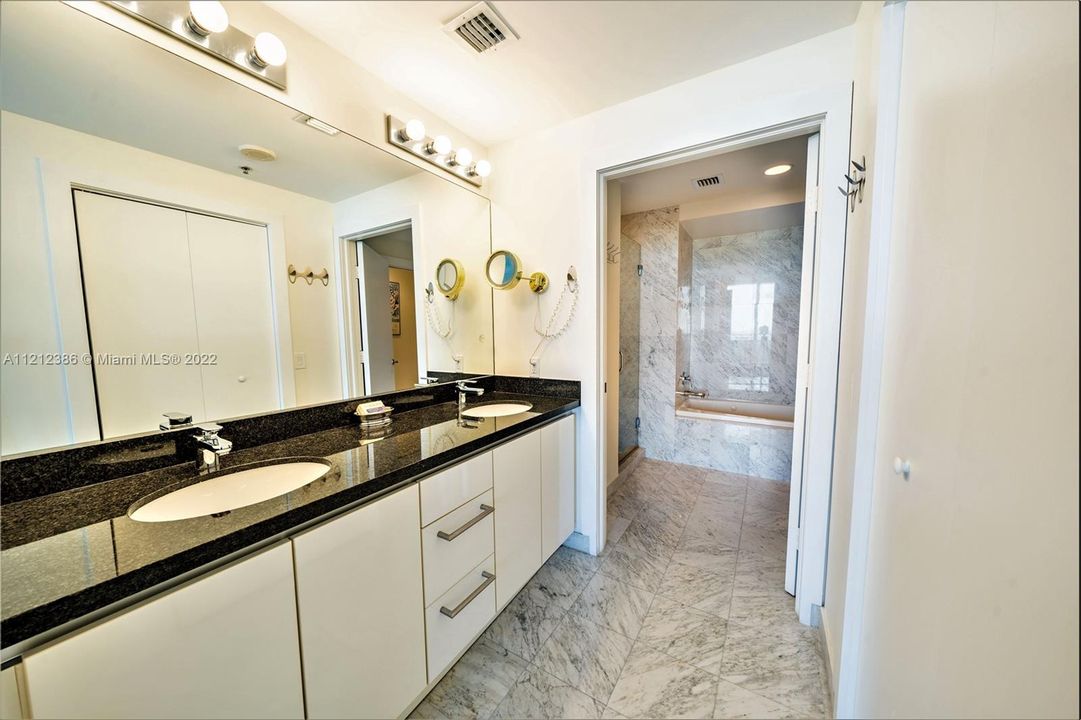 The primary bathroom is en-suite, and features double sinks, black granite countertops, and a spacious walk-in closet.