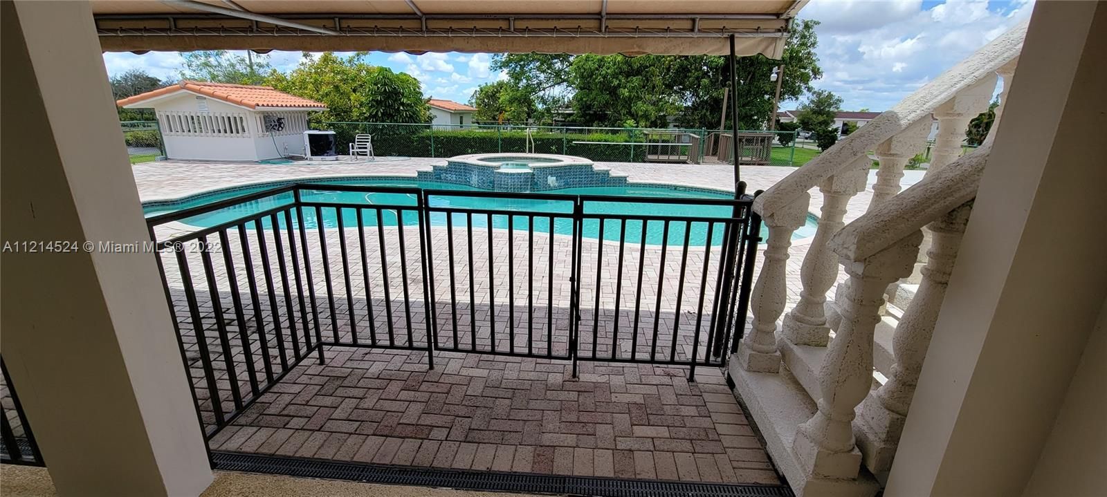 Covered patio overlooking pool/spa deck and stairway to Master suite balcony patio