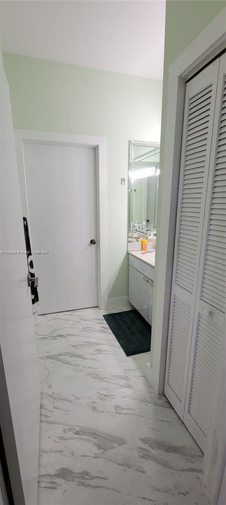 Hallway bathroom with privacy door to shower/toilet and exit to covered patio/pool