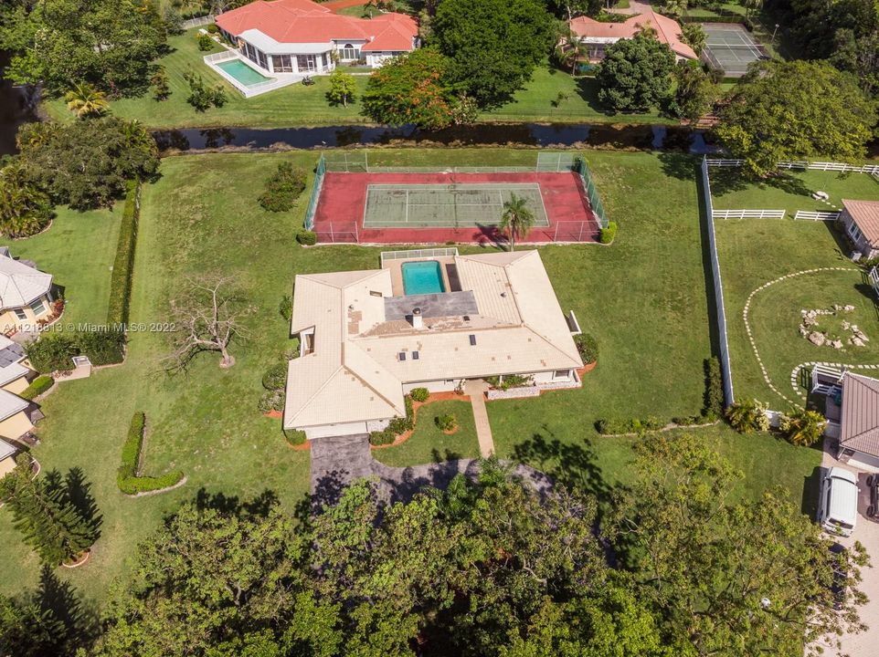 Arial of Property with canal, tennis court, pool