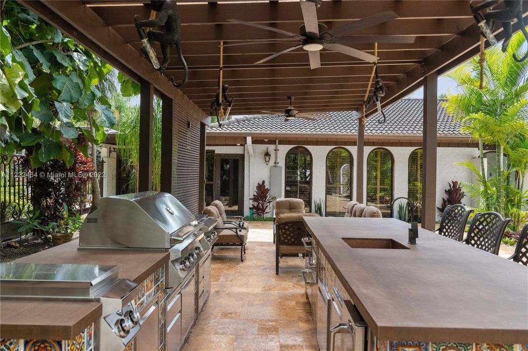 Covered outdoor kitchen by pools