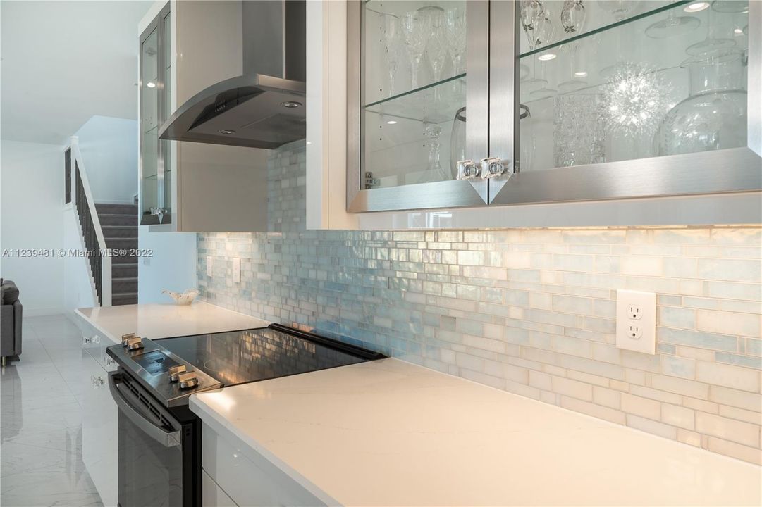 Mother of pearl subway tile backsplash, quartz counter top, GE Profile Hood