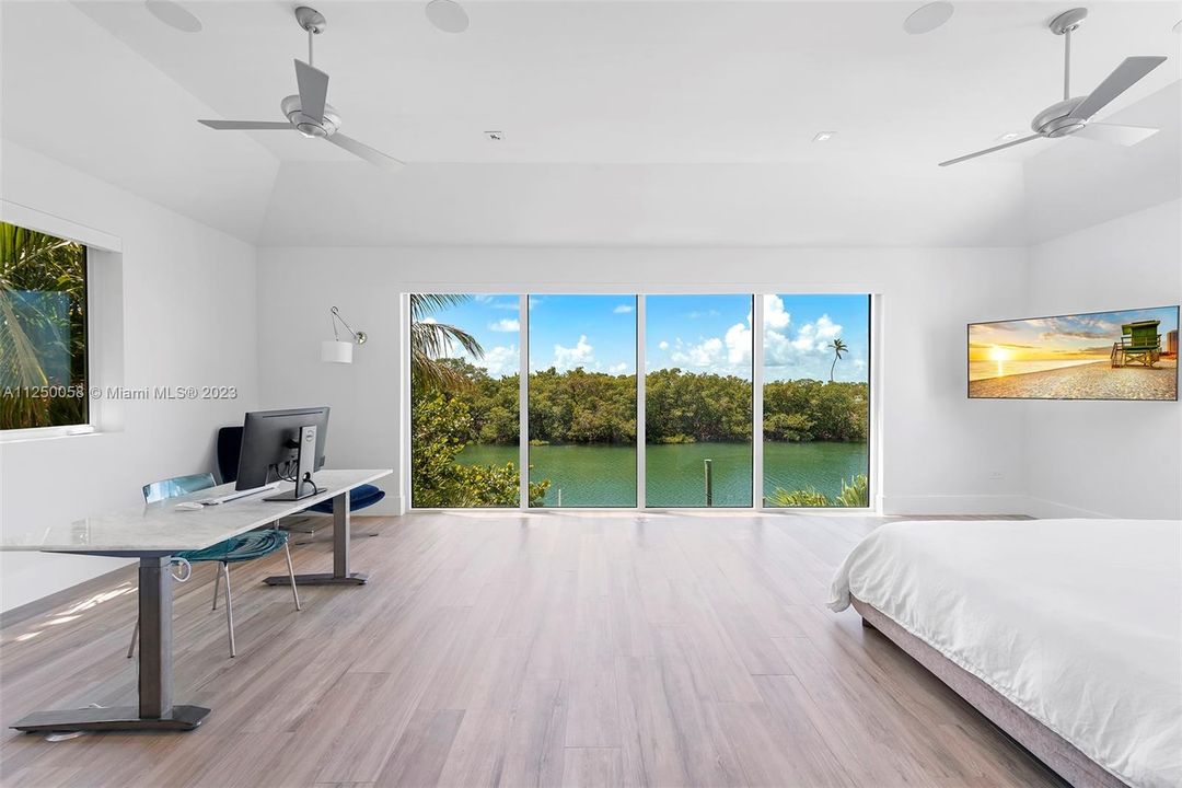 MASTER BEDROOM WITH FLOOR TO CEILING VIEWS OF PINES CANAL AND STATE PARK