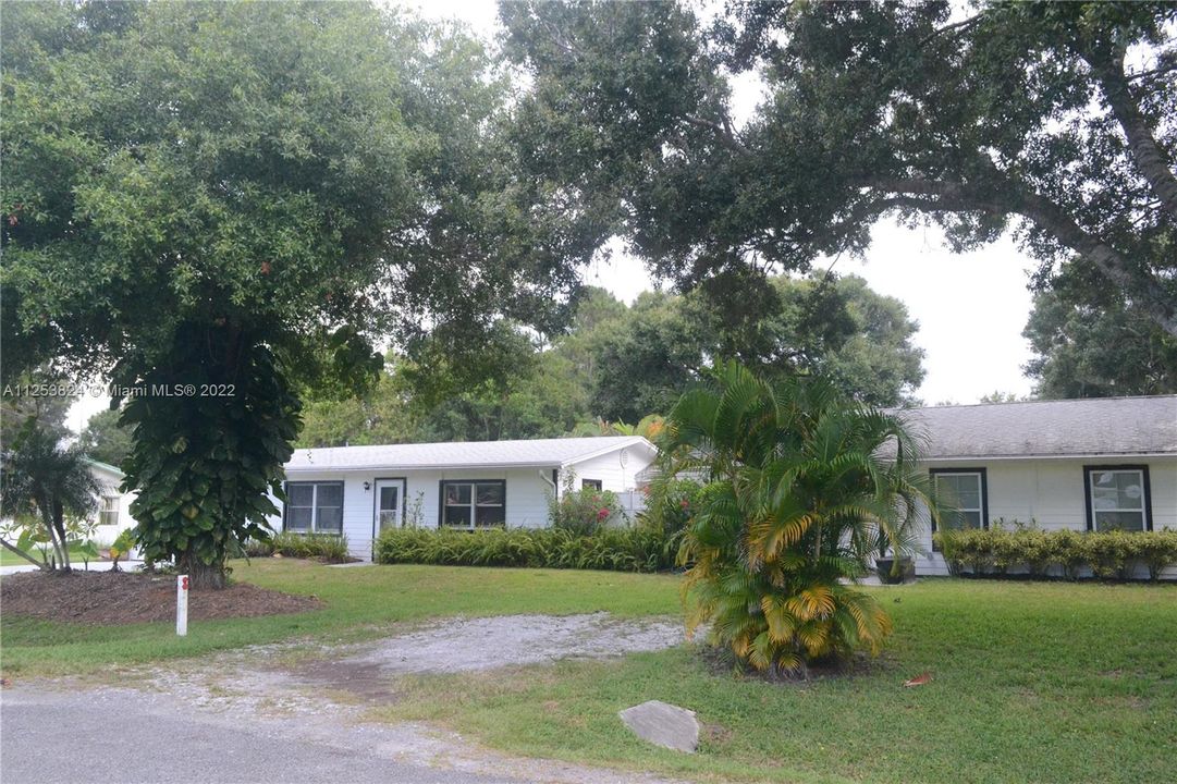 Pretty landscaping with mature trees in front.