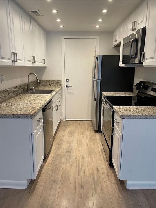 The kitchen has stainless appliances and granite countertop